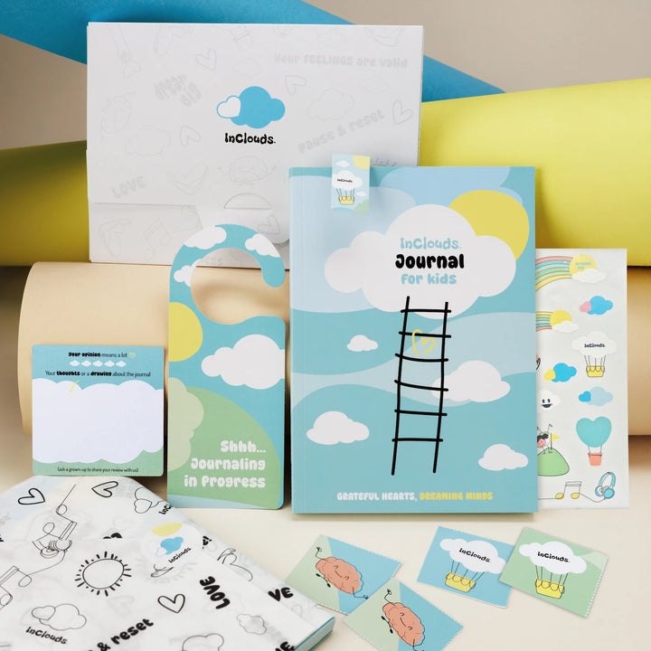 A complete InClouds. Journal gift set for kids featuring the blue prompt journal, stickers, door hanger, and custom packaging.