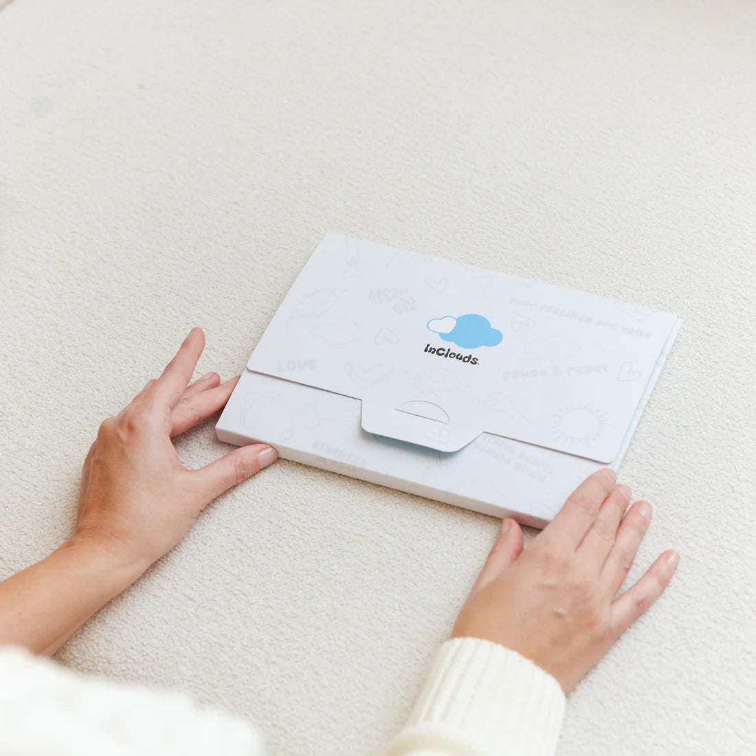 InClouds Journal white branded envelope packaging with blue cloud logo on a neutral background